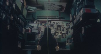 Movie still from “Perfect Blue” (1997), directed by Kô Matsuo – A person standing in front of a wall with pictures on it; Wide shot, High angle