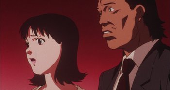 Movie still from “Perfect Blue” (1997), directed by Kô Matsuo – A man and a woman looking at each other in front of a red background; Close Up shot, Low angle