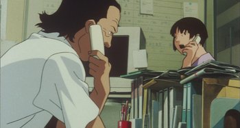 Movie still from “Perfect Blue” (1997), directed by Kô Matsuo – A man talking on a phone in front of a girl; Medium shot, Low angle