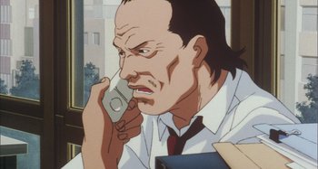 Movie still from “Perfect Blue” (1997), directed by Kô Matsuo – An animated man talking on a cell phone while wearing a tie; Close Up shot, Low angle