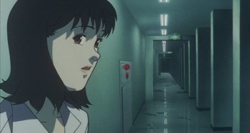 Movie still from “Perfect Blue” (1997), directed by Kô Matsuo – A woman standing in an empty hallway next to a wall; Close Up shot, Low angle
