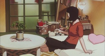 Movie still from “Perfect Blue” (1997), directed by Kô Matsuo – A woman sitting on a chair in front of a table; Wide shot, High angle