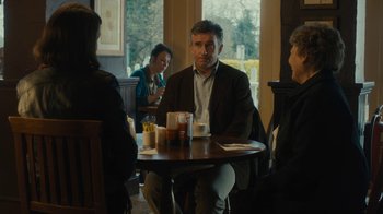 Movie still from “Philomena” (2013), directed by Stephen Frears – A group of people sitting at a table with drinks; Medium shot, Over the shoulder angle