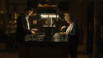Movie still from “Philomena” (2013), directed by Stephen Frears – A man and a woman preparing food in a kitchen; Medium shot, High angle