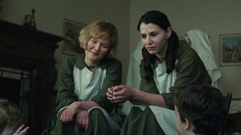 Movie still from “Philomena” (2013), directed by Stephen Frears – A group of people sitting on the ground; Medium shot, Low angle