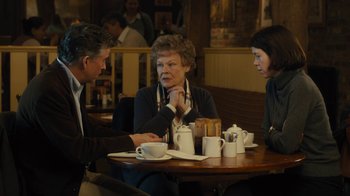 Movie still from “Philomena” (2013), directed by Stephen Frears – A group of people sitting at a table with cups; Medium shot, Over the shoulder angle