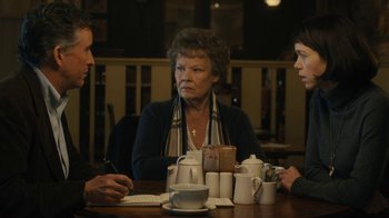 Movie still from “Philomena” (2013), directed by Stephen Frears – A group of people sitting at a wooden table; Medium shot, Over the shoulder angle