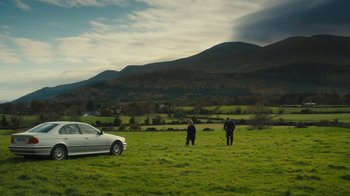 Movie still from “Philomena” (2013), directed by Stephen Frears – Two people standing in a grassy field next to a white car; Extreme Wide shot, High angle
