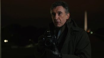Movie still from “Philomena” (2013), directed by Stephen Frears – A man holding a camera while wearing a jacket; Close Up shot, Low angle