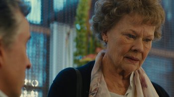 Movie still from “Philomena” (2013), directed by Stephen Frears – An older woman is looking down at the ground; Close Up shot, Over the shoulder angle