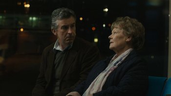 Movie still from “Philomena” (2013), directed by Stephen Frears – An older woman sitting next to a younger man in front of lights; Close Up shot, Over the shoulder angle