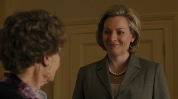 Movie still from “Philomena” (2013), directed by Stephen Frears – A woman wearing a suit and pearls talking to another woman in front of a door; Close Up shot, Over the shoulder angle