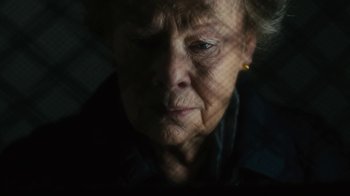 Movie still from “Philomena” (2013), directed by Stephen Frears – An older woman looking at the camera through a net; Close Up shot, High angle