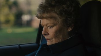 Movie still from “Philomena” (2013), directed by Stephen Frears – An older woman sitting in the back seat of a car; Close Up shot, Over the shoulder angle