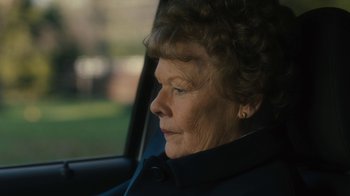 Movie still from “Philomena” (2013), directed by Stephen Frears – An older woman sitting in the driver's seat of a car; Close Up shot, Over the shoulder angle