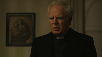 Movie still from “Philomena” (2013), directed by Stephen Frears – An older man wearing a priest's outfit; Close Up shot, Over the shoulder angle