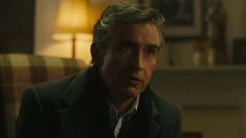 Movie still from “Philomena” (2013), directed by Stephen Frears – A person wearing a suit and tie; Close Up shot, Over the shoulder angle