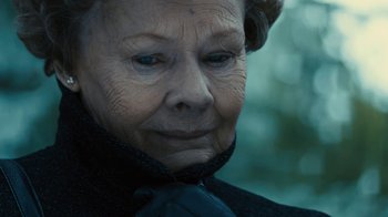 Movie still from “Philomena” (2013), directed by Stephen Frears – An older woman with a black tie looking at the camera; Close Up shot, Over the shoulder angle