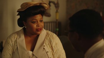 Movie still from “A League of Their Own” (2022), created by Abbi Jacobson – An older woman wearing a hat looking to her left; Close Up shot, Over the shoulder angle