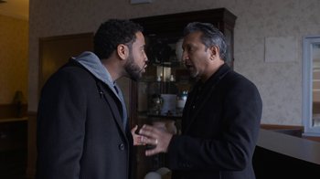 Movie still from “Full Circle” (2023), directed by Steven Soderbergh – Two men talking to each other in front of a glass case; Medium shot, Over the shoulder angle