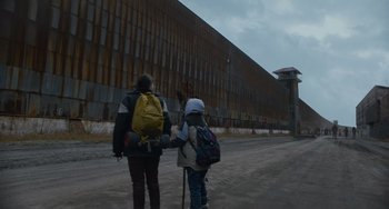 A woman and a young child walking down a street