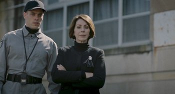 A woman standing next to a man with her arms crossed