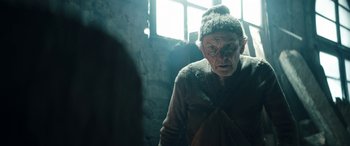 Movie still from “Pinocchio” (2019), directed by Matteo Garrone – An old man wearing a hat and looking at the camera; Medium shot, Low angle