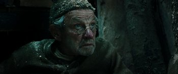 Movie still from “Pinocchio” (2019), directed by Matteo Garrone – An old man wearing a hat and glasses looking into the distance; Close Up shot, Low angle