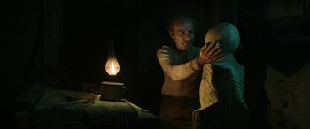 Movie still from “Pinocchio” (2019), directed by Matteo Garrone – An old man is working on a statue; Medium shot, Low angle