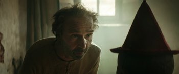 Movie still from “Pinocchio” (2019), directed by Matteo Garrone – An older man is looking at the camera; Close Up shot, Over the shoulder angle