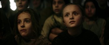 Movie still from “Pinocchio” (2019), directed by Matteo Garrone – A group of people sitting in a room; Close Up shot, Low angle