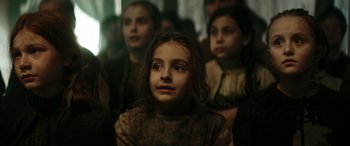 Movie still from “Pinocchio” (2019), directed by Matteo Garrone – A group of children sitting in a room; Close Up shot, Over the shoulder angle