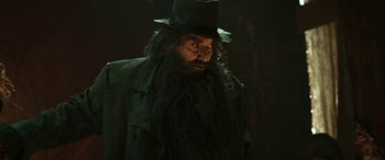 Movie still from “Pinocchio” (2019), directed by Matteo Garrone – A man with a long beard wearing a black hat; Close Up shot, Low angle
