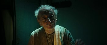 Movie still from “Pinocchio” (2019), directed by Matteo Garrone – An old man with a white beard is looking at the camera; Close Up shot, Low angle