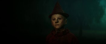 Movie still from “Pinocchio” (2019), directed by Matteo Garrone – A creepy looking doll wearing a hat and a red jacket; Close Up shot, Low angle