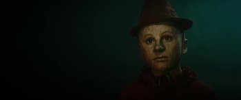 Movie still from “Pinocchio” (2019), directed by Matteo Garrone – A child with a fake nose and a hat on; Close Up shot, Low angle