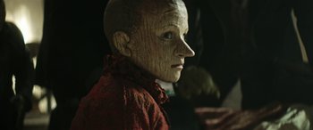 Movie still from “Pinocchio” (2019), directed by Matteo Garrone – A person's face in a red shirt; Close Up shot, Low angle