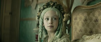 Movie still from “Pinocchio” (2019), directed by Matteo Garrone – A young girl with green hair and a flower crown; Close Up shot, Low angle