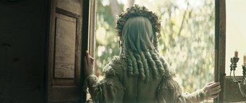 Movie still from “Pinocchio” (2019), directed by Matteo Garrone – A person with long green hair looking out of a window; Close Up shot, Over the shoulder angle