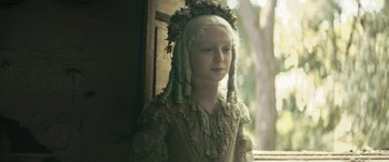 Movie still from “Pinocchio” (2019), directed by Matteo Garrone – A young girl with long blonde hair wearing a dress and a wreath; Close Up shot, High angle