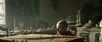 Movie still from “Pinocchio” (2019), directed by Matteo Garrone – A creepy looking head with a long stalk of hair coming out of it's mouth; Extreme Close Up shot, Low angle