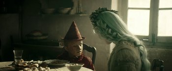Movie still from “Pinocchio” (2019), directed by Matteo Garrone – A woman and a boy dressed as a scarecrow and a girl dressed as an elf; Close Up shot, Over the shoulder angle