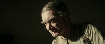 Movie still from “Pinocchio” (2019), directed by Matteo Garrone – An older man with long gray hair looking to his left; Close Up shot, Low angle