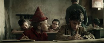Movie still from “Pinocchio” (2019), directed by Matteo Garrone – A group of people sitting at a table; Close Up shot, Low angle