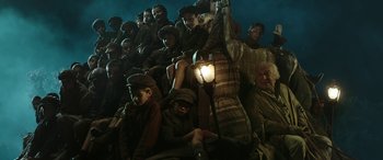 Movie still from “Pinocchio” (2019), directed by Matteo Garrone – A group of people sitting next to each other on a stage; Wide shot, High angle