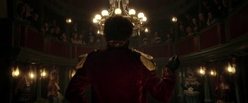 Movie still from “Pinocchio” (2019), directed by Matteo Garrone – A man in a red jacket is standing in front of a mirror; Medium shot, Low angle