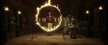 Movie still from “Pinocchio” (2019), directed by Matteo Garrone – A man is standing in front of a ring of fire; Wide shot, High angle