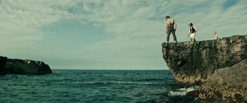 Movie still from “Pinocchio” (2019), directed by Matteo Garrone – A man standing on top of a rock in the middle of the ocean; Extreme Wide shot, Low angle