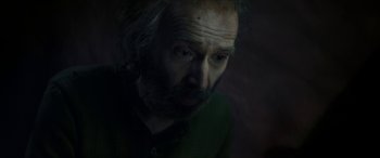 Movie still from “Pinocchio” (2019), directed by Matteo Garrone – A man with long hair and a goatee stares into the camera; Close Up shot, Overhead angle