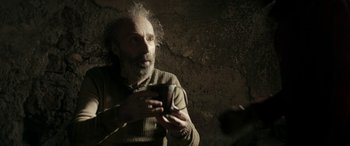 Movie still from “Pinocchio” (2019), directed by Matteo Garrone – An older man holding a cell phone in his hands; Close Up shot, Over the shoulder angle